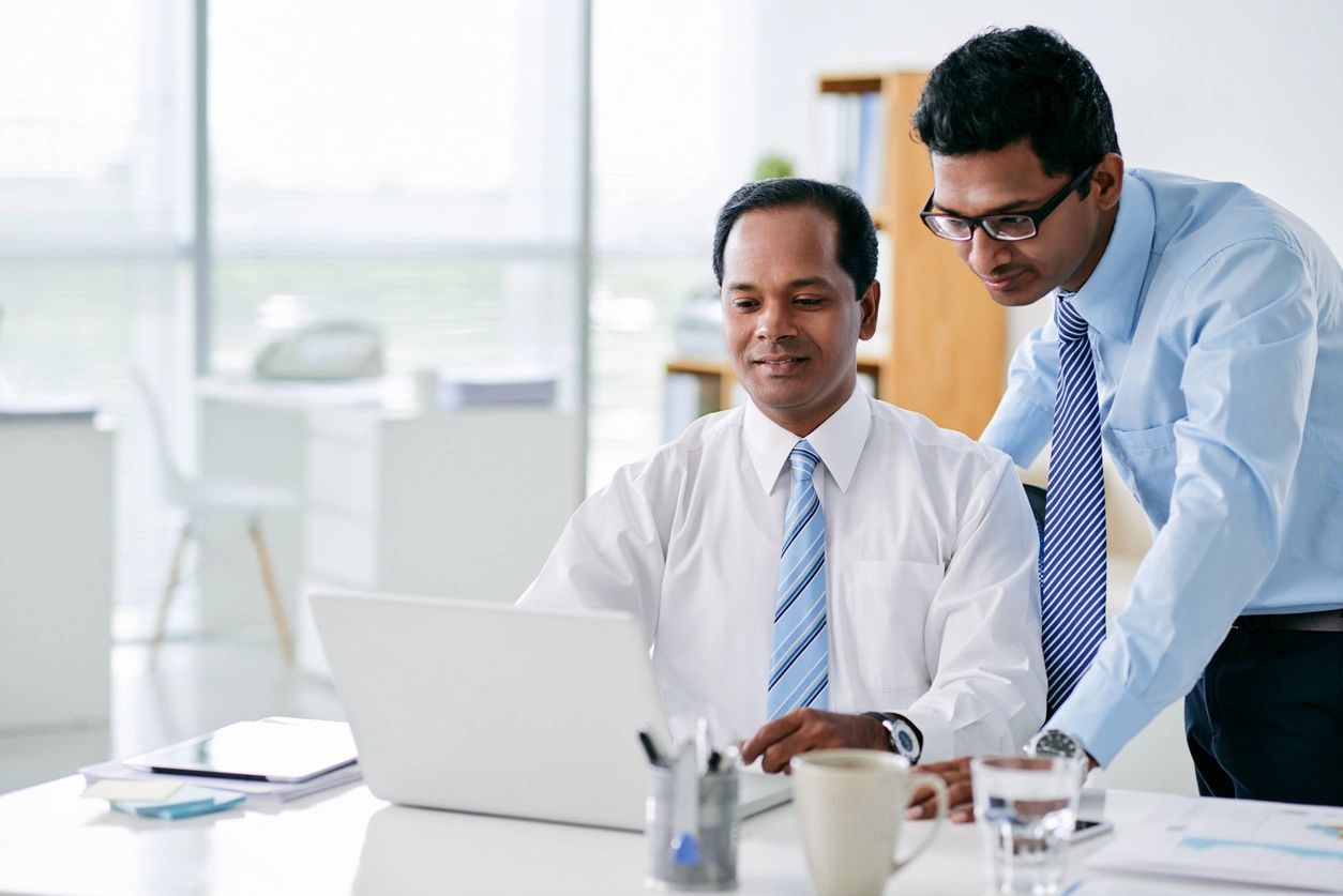 Two businessmen collaborating at laptop